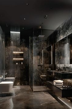 a large bathroom with black marble walls and floor, along with a walk in shower