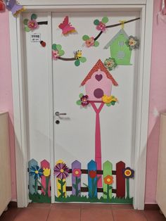 a door decorated with paper flowers and a birdhouse