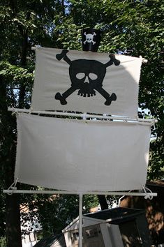 a pirate flag with a skull and crossbones on it in front of some trees