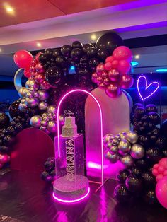 a table topped with balloons and a bottle of booze in front of a backdrop