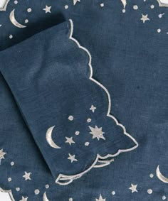 a blue table cloth with white stars and a christmas tree design on it, in front of a night sky background