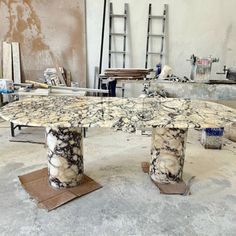 an artisticly designed table sits in the middle of a room that is being worked on