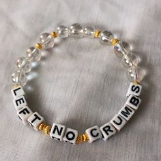 a beaded bracelet that says let no crumbs on it