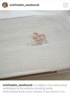 an embroidered piece of cloth with flowers on it and the words nick franklin needledwork