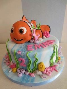 a birthday cake decorated to look like an orange fish and seaweed with the name emmet on it