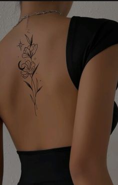 the back of a woman's body with a flower tattoo on her left side