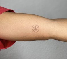 a person's arm with a small starfish tattoo on the left side of their arm