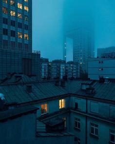 an image of the city at night with buildings in the background and foggy sky