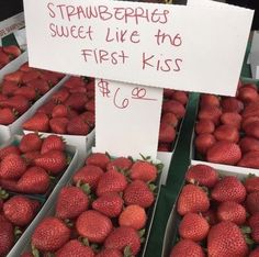 strawberries for sale at a farmers market with a sign that says strawberrys sweet like the first kiss