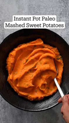 a bowl full of mashed sweet potatoes with a spoon in it and the words instant pot paleo mashed sweet potatoes