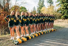 the cheerleaders are lined up in green and yellow outfits for their team photo