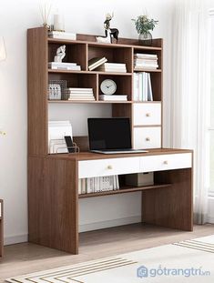 a computer desk with a laptop on top of it in front of a bookcase