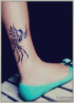 a woman's foot with a bird tattoo on it