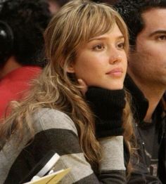 a man and woman sitting next to each other at a basketball game