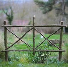 an old wooden gate in the middle of some grass