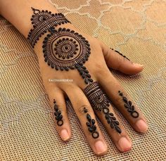 a woman's hand with henna tattoos on it