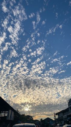 the sky is filled with clouds and cars