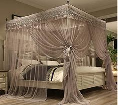 a canopy bed with sheer curtains on it