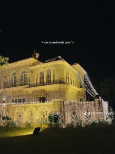 a large yellow building with lights on it's side and trees in the background