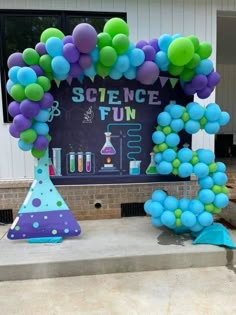 a science themed birthday party with balloons and streamers in the shape of an arch