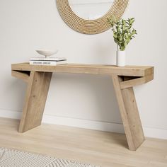 a wooden table with a plant on it and a mirror in the corner behind it