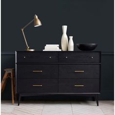 a black and gold dresser with two vases sitting on it's top shelf