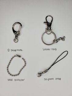 four different types of key chains on a white surface with words written in black ink