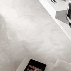 an aerial view of a living room with white furniture and tile flooring that looks like marble