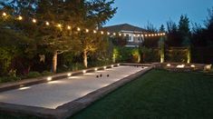 a backyard with lights strung around the perimeter