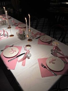 the table is set with pink napkins and place settings for an elegant dinner party