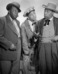 three men in suits and hats standing next to each other