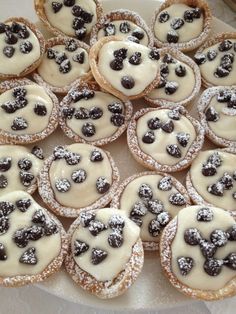 a white plate topped with lots of cookies covered in frosting