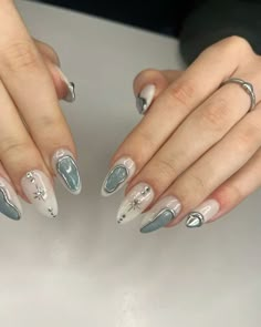 two hands with silver and white manies on them