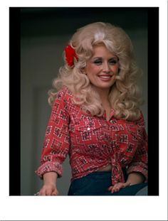 a woman with blonde hair sitting down and smiling