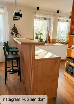 a kitchen with an island in the middle and two stools at the counter top