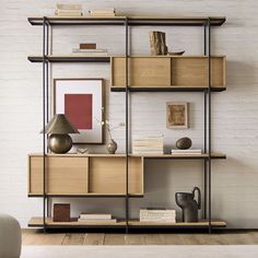 a shelf with books, vases and pictures on it