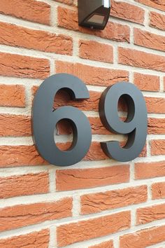 the number 69 is displayed on a brick wall