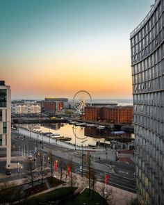 an aerial view of a city with a ferris wheel in the distance and buildings around it