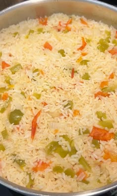 a pan filled with rice and vegetables on top of a stove