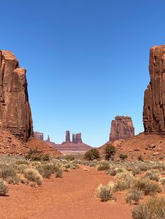 a dirt road in the desert with rocks and grass