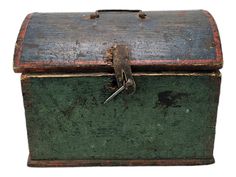 an old green and red box with a key on the top is isolated against a white background