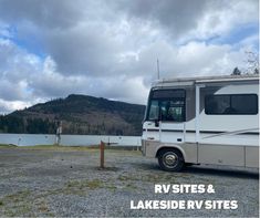 an rv parked next to a lake with mountains in the background