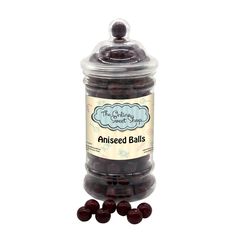 an open jar filled with chocolate covered balls on top of a white surface and in front of it is a label that says,