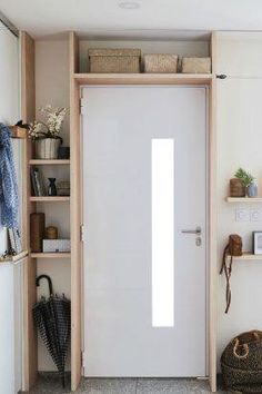 a white door in a room with shelving and baskets on the shelves next to it