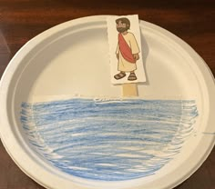 a paper plate with an image of jesus on it and a stick sticking out of the water