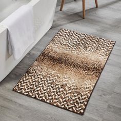 a bath tub sitting next to a rug in a bathroom