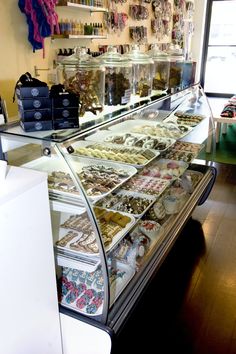 a display case filled with lots of different types of pastries and desserts on top of glass shelves