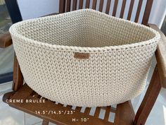 a crocheted basket sitting on top of a wooden chair