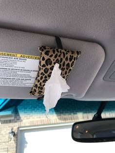 the interior of a car with an animal print bag hanging from it's ceiling