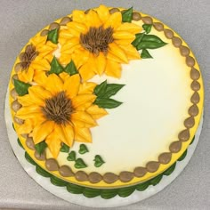 a cake decorated with sunflowers and green leaves